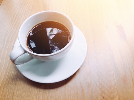 Coffee in white glass on wooden boardsの写真素材