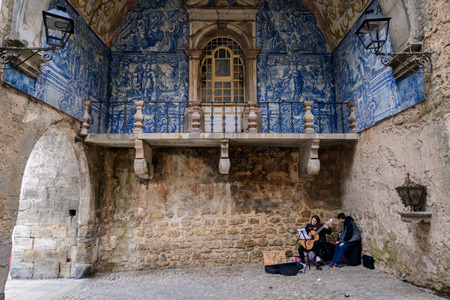 OBIDOS, PORTUGAL - FEBRUARY 06, 2016: Street musicians under the balcony decorated with ceramic tiles (azulejos) in blue tones - Obidos, Portugalのeditorial素材