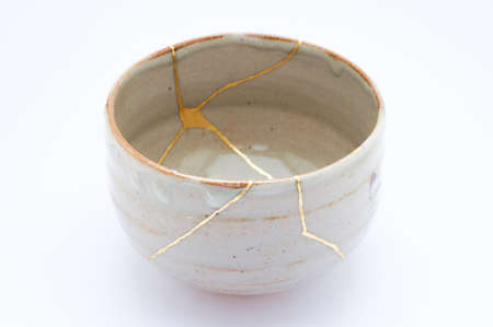 Kintsugi bowl. Gold cracks restoration on old Japanese pottery restored with the antique restoration technique.の写真素材