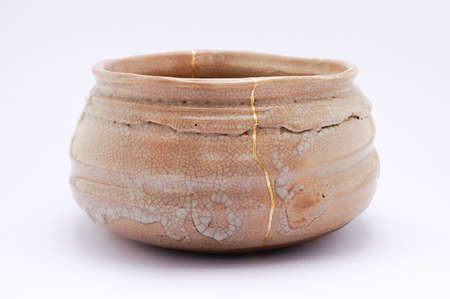 Kintsugi bowl. Gold cracks restoration on old Japanese pottery restored with the antique restoration technique.の写真素材