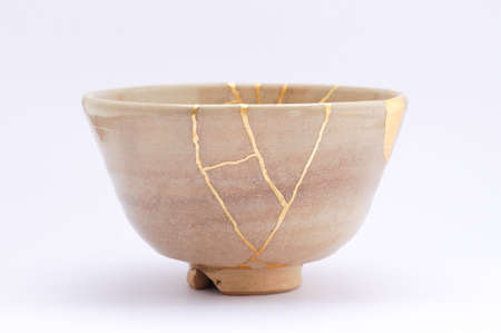 Kintsugi bowl. Gold cracks restoration on old Japanese pottery restored with the antique restoration technique.の写真素材