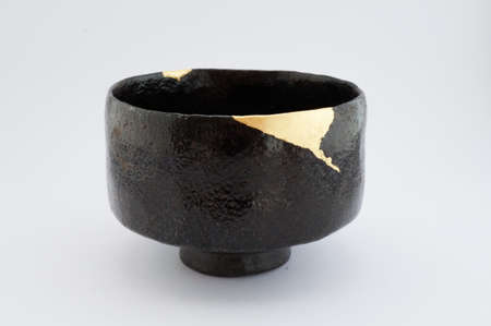 Kintsugi bowl. Gold cracks restoration on old Japanese pottery restored with the antique restoration technique.の写真素材