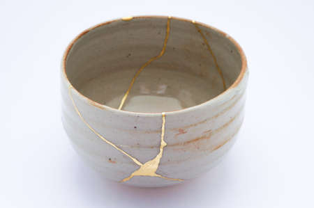 Kintsugi bowl. Gold cracks restoration on old Japanese pottery restored with the antique restoration technique.の写真素材