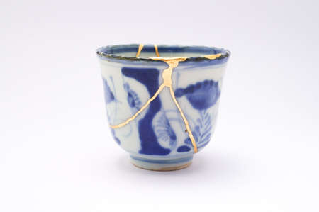 Kintsugi soba cup. Gold cracks restoration on old Japanese pottery restored with the antique restoration technique The unique beauty of imperfections.の写真素材