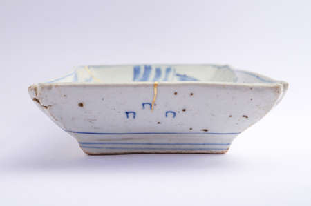 Kintsugi plate. Gold cracks restoration on old Japanese pottery restored with the antique restoration technique The unique beauty of imperfections.の写真素材