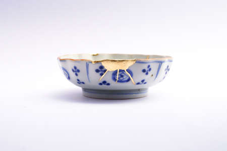 Kintsugi plate. Gold cracks restoration on old Japanese pottery restored with the antique restoration technique The unique beauty of imperfections.の写真素材
