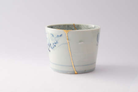 Kintsugi soba cup. Gold cracks restoration on old Japanese pottery restored with the antique restoration technique The unique beauty of imperfections.の写真素材