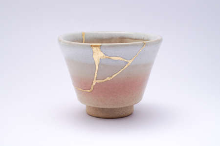 Kintsugi soba cup. Gold cracks restoration on old Japanese pottery restored with the antique restoration technique The unique beauty of imperfections.の写真素材