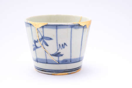 Kintsugi soba cup. Gold cracks restoration on old Japanese pottery restored with the antique restoration technique The unique beauty of imperfections.の写真素材