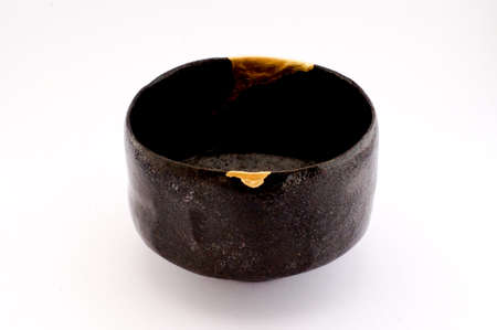 Kintsugi pottery. Gold cracks restoration on old Japanese pottery restored with the antique Kintsugi restoration technique. The beauty of imperfections.の写真素材