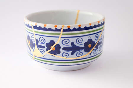 Kintsugi pottery. Gold cracks restoration on old Japanese pottery restored with the antique Kintsugi restoration technique. The beauty of imperfections.の写真素材