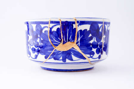 Kintsugi pottery. Gold cracks restoration on old Japanese pottery restored with the antique Kintsugi restoration technique. The beauty of imperfections.の写真素材