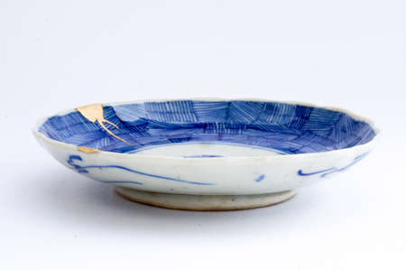 Kintsugi pottery. Gold cracks restoration on old Japanese pottery restored with the antique Kintsugi restoration technique. The beauty of imperfections.の写真素材