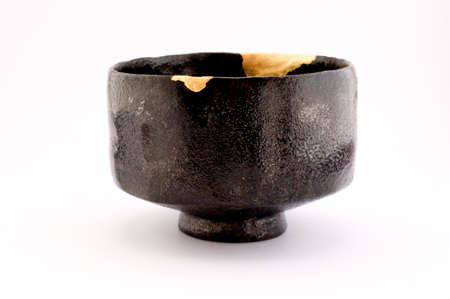Kintsugi pottery. Gold cracks restoration on old Japanese pottery restored with the antique Kintsugi restoration technique. The beauty of imperfections.の写真素材