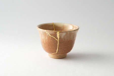 Kintsugi pottery. Gold cracks restoration on old Japanese pottery restored with the antique Kintsugi restoration technique. The beauty of imperfections.の写真素材