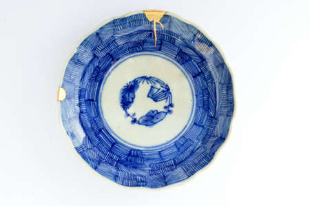 Kintsugi pottery. Gold cracks restoration on old Japanese pottery restored with the antique Kintsugi restoration technique. The beauty of imperfections.の写真素材