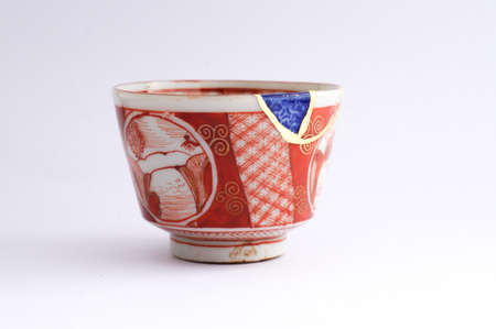Kintsugi pottery. Gold cracks restoration on old Japanese pottery restored with the antique Kintsugi restoration technique. The beauty of imperfections.の写真素材