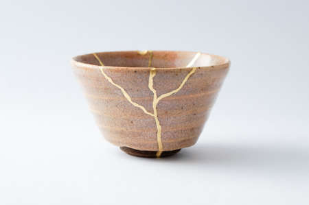 Kintsugi pottery. Gold cracks restoration on old Japanese pottery restored with the antique Kintsugi restoration technique. The beauty of imperfections.の写真素材