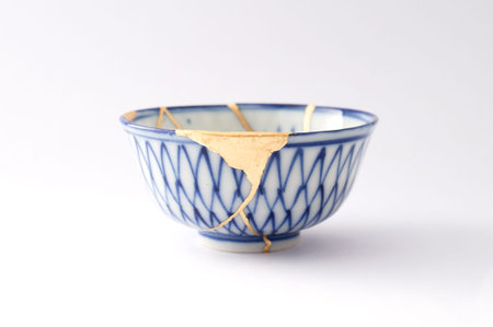 Kintsugi pottery. Gold cracks restoration on old Japanese pottery restored with the antique Kintsugi restoration technique. The beauty of imperfections.