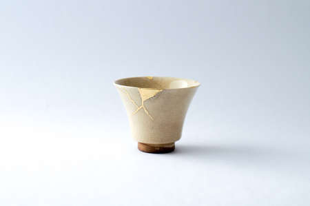Kintsugi pottery. Gold cracks restoration on old Japanese pottery restored with the antique Kintsugi restoration technique. The beauty of imperfections.の写真素材