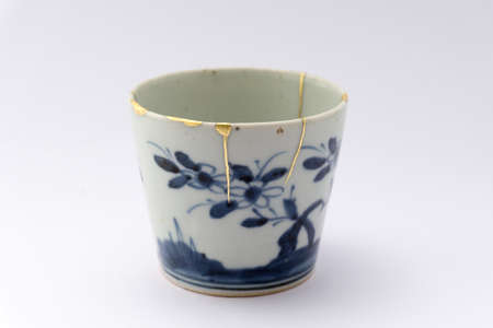 Kintsugi pottery. Gold cracks restoration on old Japanese pottery restored with the antique Kintsugi restoration technique. The beauty of imperfections.の写真素材