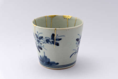 Kintsugi pottery. Gold cracks restoration on old Japanese pottery restored with the antique Kintsugi restoration technique. The beauty of imperfections.の写真素材