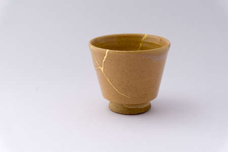 Kintsugi pottery. Gold cracks restoration on old Japanese pottery restored with the antique Kintsugi restoration technique. The beauty of imperfections.の写真素材