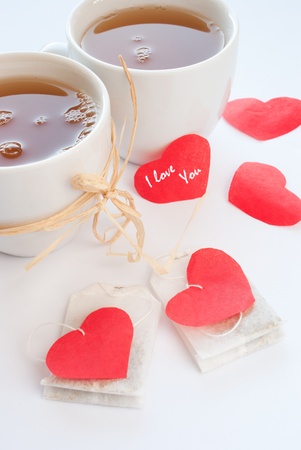  mugs with chamomile tea and red heartsの写真素材