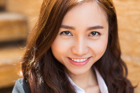 Close up portrait of smiling young Asian businesswoman looking at cameraの写真素材
