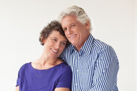 Portrait of smiling senior husband embracing pensive wife. Happy man looking at camera, while his beloved woman looking away. Relationship conceptの写真素材