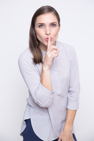 Young woman holding index finger near mouthの写真素材