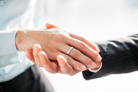 Man holding female hand with engagement ring