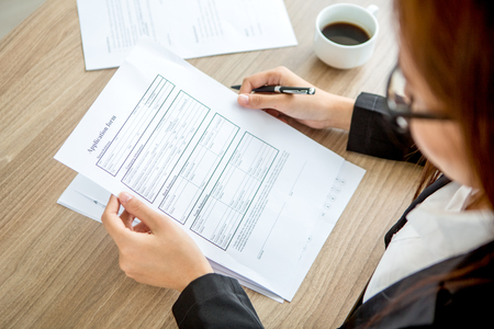 Young businesswoman reading application formの写真素材