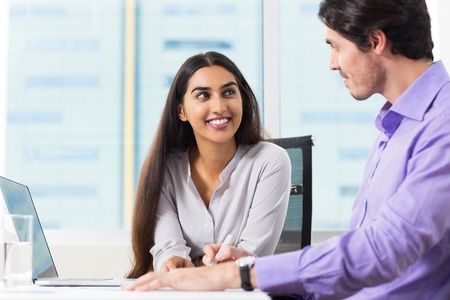 Smiling Male and Female Coworkers Talking at Workの写真素材