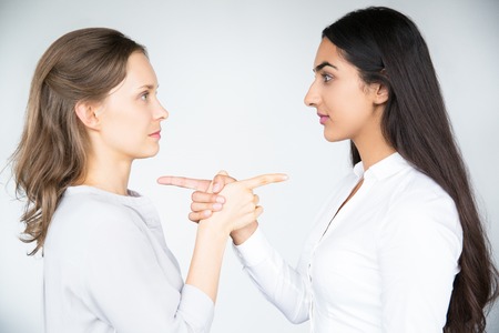 Serious businesswomen pointing at each otherの写真素材