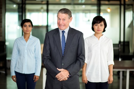 Smiling senior businessman with multiethnic teamの写真素材