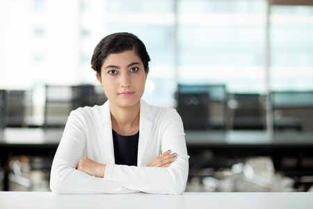 Confident young businesswoman sitting at tableの写真素材