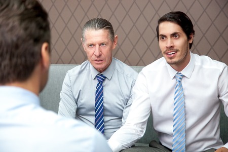 Emotional young businessman talking to colleaguesの写真素材