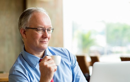 Closeup of Middle-aged Businessman Drinking Coffeeの写真素材