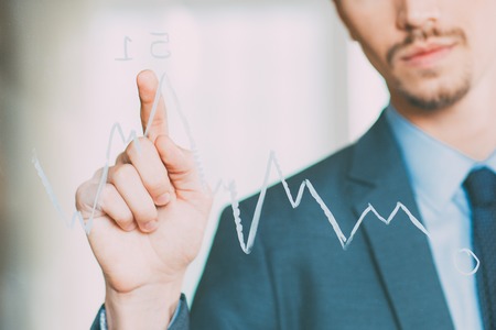 Closeup of Businessman Pointing to Graph on Glassの写真素材