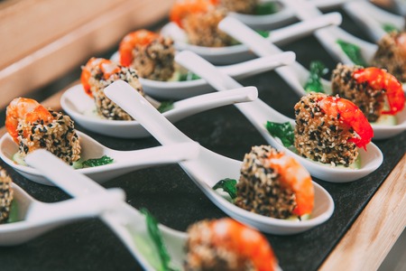 Snacks with Shrimps in Spoons on Buffet Tableの写真素材