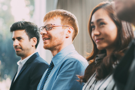 Business people listening to speaker and smilingの写真素材