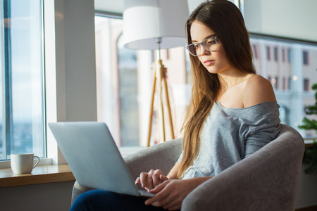 Young Beautiful Woman Working on Laptop at Homeの写真素材