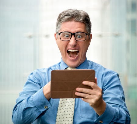 Shocked Middle-aged Business Man Using Touchpadの写真素材