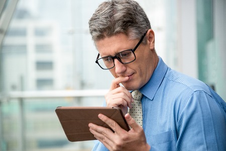 Closeup of Thoughtful Business Man Using Touchpadの写真素材