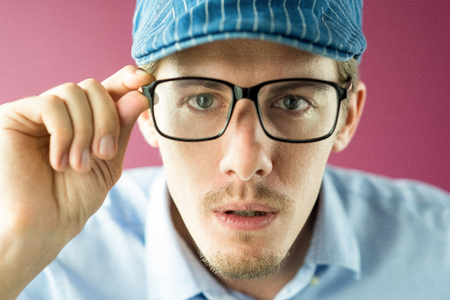 Close-up of surprised man looking through glasses