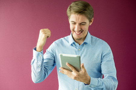 Happy businessman with touchpad gesturing success