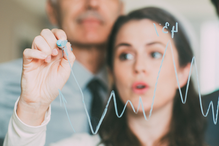 Graph Drawn on Glass and Blurred Business Peopleの写真素材