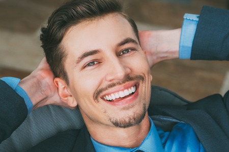 Top View of Smiling Man with Hands Behind Headの写真素材