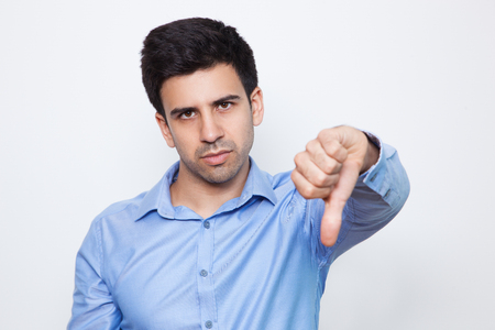 Disappointed Young Handsome Man Showing Thumb Downの写真素材